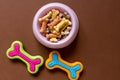 Close up of a Dog bowl, bones on brown background. Dog accessories. Minimalistic background. Royalty Free Stock Photo