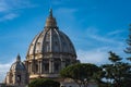 Close up of Dome of  St. Peter`s Basilica during sunny weather. Green trees, blue sky and Sain Peter`s Basilica in Vatican Royalty Free Stock Photo