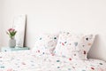 Close-up of dotted pillows and sheets next to bedside table with