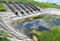 Close-up on downpipes, waste water pipes. Overflow pipes of flood control system going into the pond