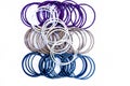 Close up of dozen of white and blue colored bangles along with a dozen  of purple and orange colored bangles isolated on white. Royalty Free Stock Photo