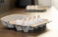 Close up of dozen white eggs in cardboard box on kitchen table Royalty Free Stock Photo