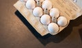 Close up of dozen white eggs in cardboard box on kitchen table Royalty Free Stock Photo