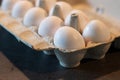 Close up of dozen white eggs in cardboard box on kitchen table Royalty Free Stock Photo