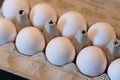 Close up of dozen white eggs in cardboard box on kitchen table Royalty Free Stock Photo