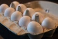 Close up of dozen white eggs in cardboard box on kitchen table Royalty Free Stock Photo