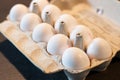 Close up of dozen white eggs in cardboard box on kitchen table Royalty Free Stock Photo