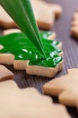 Close up of drawing Christmas tree sugar cookie on wooden table background with icing Royalty Free Stock Photo