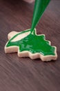 Close up of drawing Christmas tree sugar cookie on wooden table background with icing Royalty Free Stock Photo