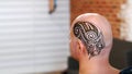 A close-up of the drawing, ornament, henna tattoo, on the scalp, shoulder, neck. The solution of henna dries on the skin