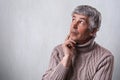 A close-up of dreamy elderly male holding his hand under chin looking aside having thoughtful faraway expression. Mature man daydr Royalty Free Stock Photo