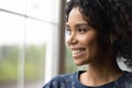 Close up dreamy smiling African American woman, looking out window Royalty Free Stock Photo