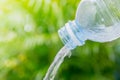 Drinking water pouring from a plastic bottle on green background Royalty Free Stock Photo