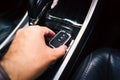 Close up of a driver hand holding a remote control of a car, car keyless entry remote on the auto transmission panel