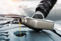 Close-up driver hand holding small bottle can pouring synthetic motor oil in diesel or petrol turbocharged vehicle Royalty Free Stock Photo