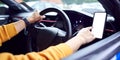 Close Up Of Driver With Hands Free Unit For Mobile Phone Mounted On Dashboard