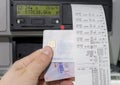 Close up of a driver holding printed day shift in focus together with drivers licence and digital tachograph card .