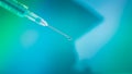 Close up drop of vaccine from Syrian needle in blue abstract background Royalty Free Stock Photo