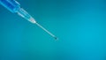 Close up drop of vaccine from Syrian nidle in blue abstract background