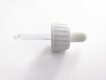 Close up Dropper cap for screw-on bottles. White dropper pipette in horizontal position on white background