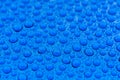 Close-up of drops of rainwater on blue metal background