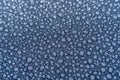 Close-up of drops of rainwater on blue metal background