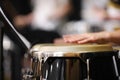 A close up of a drummer playing congas or percussion instrument with their hands