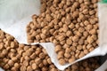 Close-up of dry pelleted pet food. Brown round pellets inside an open white bag. Pet food Royalty Free Stock Photo