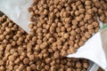 Close-up of dry pelleted pet food. Brown round pellets inside an open white bag. Pet food Royalty Free Stock Photo