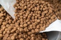 Close-up of dry pelleted pet food. Brown round pellets inside an open white bag. Pet food Royalty Free Stock Photo