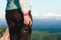 Close-up DSLR camera in the hands of the girl photographer in nature with a camera in hand. Side view