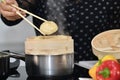 Select focus of a dumpling being put into a traditional chinese bamboo steamer on an out of focus background Royalty Free Stock Photo