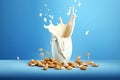 Close up of dynamic splashes of almond milk and flying nuts on a bright blue background