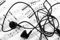 Close up of ear buds and sheet music Royalty Free Stock Photo