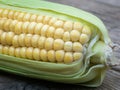 Close-up of an ear of corn on a wooden unpainted tabletop