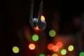 Close up of earphone hanging with colorful bokeh light on dark background. Copy space Royalty Free Stock Photo