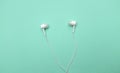 Close up Earphones on isolate green pastel backgroud.