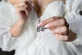 Earrings with precious stones in the hands of the bride, close-up. The concept of the morning of the bride, wedding day Royalty Free Stock Photo