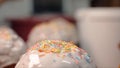 Close-up of easter cakes sprinkled with sprinkles. Stock footage. On sweet glazed white easter cakes pour rainbow