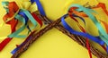 Close up of Easter handmade whips with colorful ribbons on yellow background