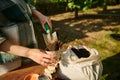 Close-up eco farmer, amateur agriculturist putting fertilized black soil into peat pots. Spring planting ad gardening.