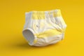 Close-up of an eco-friendly, reusable baby diaper with yellow patterns isolated on a yellow background.