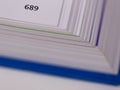 The edge of an opened book with the page number and blurry pages and cover Royalty Free Stock Photo