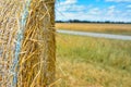 Close up of edge of round hay bale on agricultural field in front of blurry field Royalty Free Stock Photo