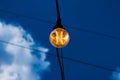 Close up of an Edison-style filament on a light bulb against a cloudy sky. Energy crisis Royalty Free Stock Photo