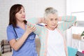 Close-up of elder woman training with physiotherapist, elderly woman with nurse at home