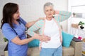 Close-up of elder woman training with physiotherapist, elderly woman with nurse at home