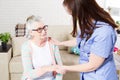 Close-up of elder woman training with physiotherapist, elderly woman with nurse at home