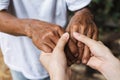 Close-up of elderly caregiver and daughter's hands