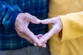 Close-up of the elderly couple showing making a heart with fingers. Concept of aged people and love Royalty Free Stock Photo